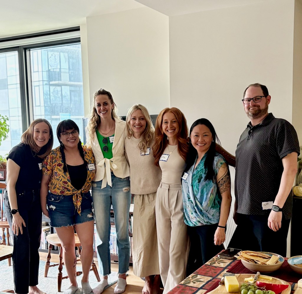 Photo of 7 founding members of The Athlete Community Clinicians, standing together and smiling. It was their first in-person meeting.